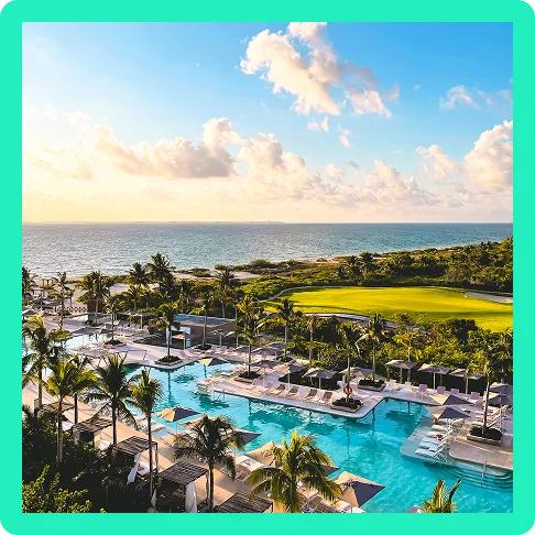Image Description: A zoomed-out view shows a resort pool with a golf course and the ocean in the distance.