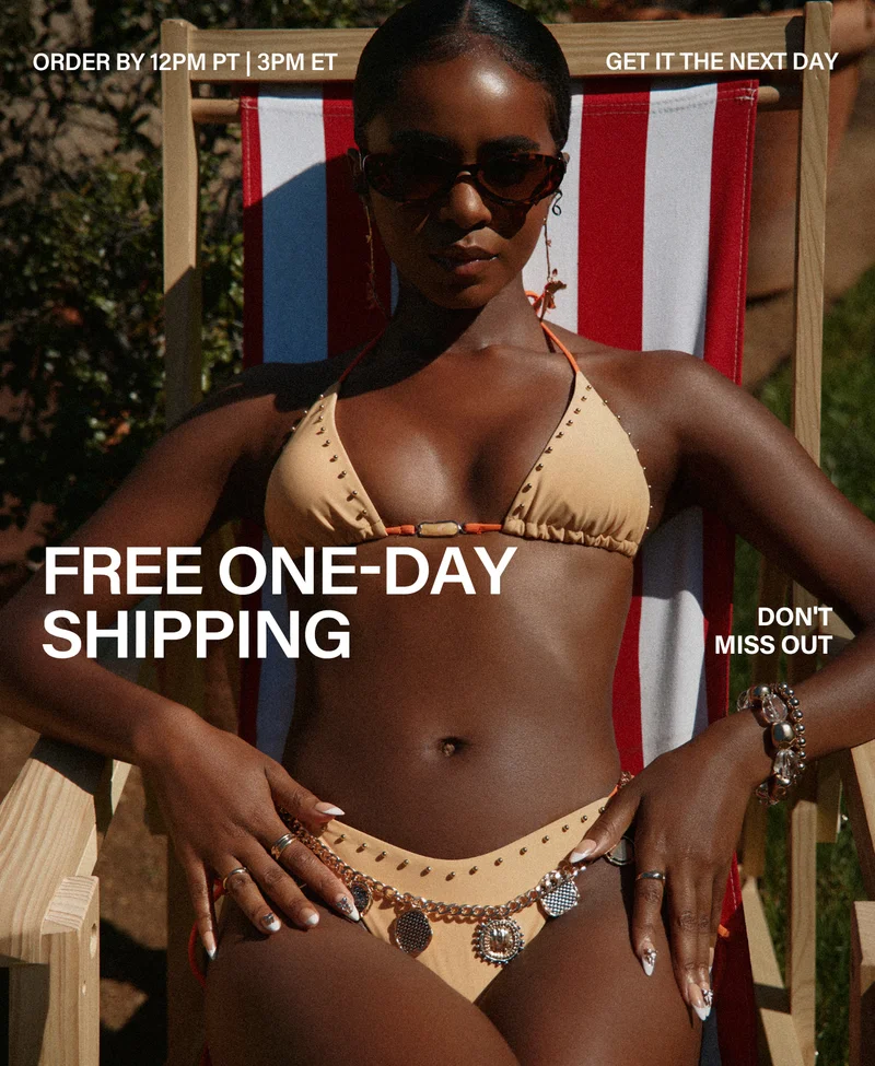 Woman in sunglasses, tan studded bikini, sitting in red-striped chair. Free one-day shipping on chic swimwear for next-day delivery.