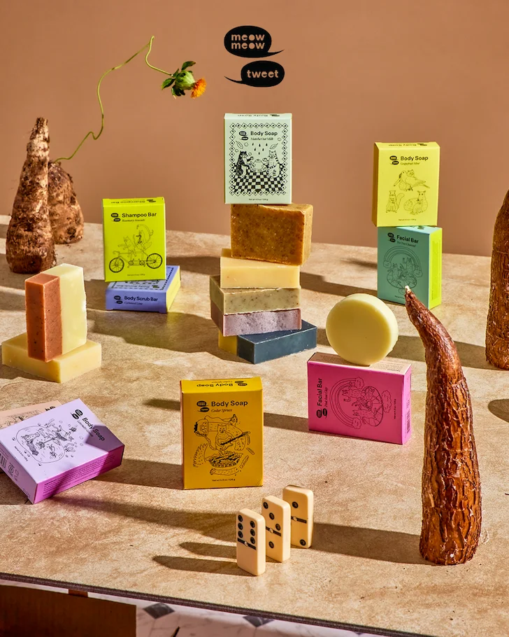 A collection of colorful boxes of soap arranged with various objects like gourds and dominos
