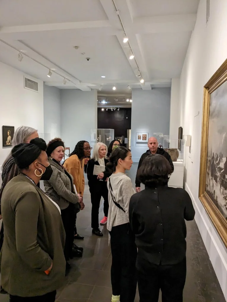 A group of people look at art on a gallery wall