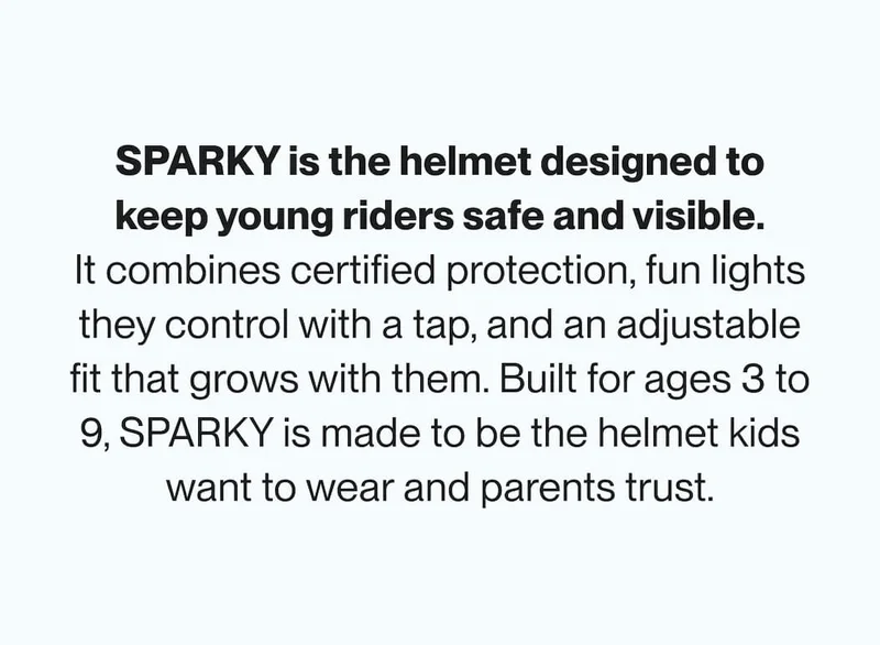 Child wearing a blue SPARKY smart helmet with the rear light on while riding outdoors.