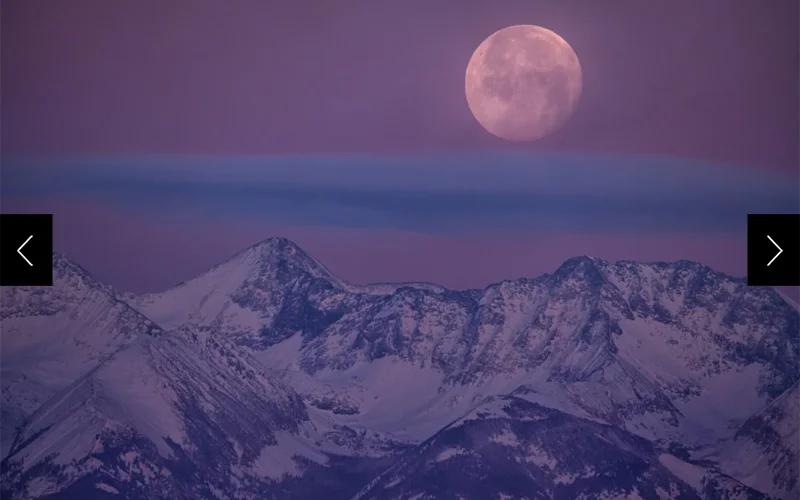 A 'wolf moon' hovers over the frigid Sangre De Cristo Mountains at twilight, San Luis Valley, Colorado.