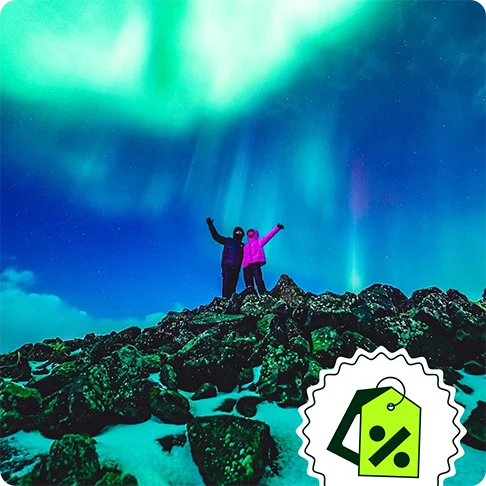 Image Description: Two people on a mountain with the northern lights in the background. A price tag icon is on the bottom right of the image.