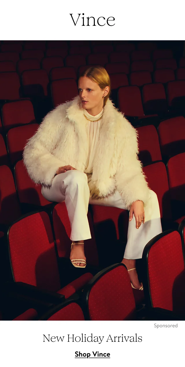 A woman wearing a shaggy faux-fur jacket over a cream blouse and trousers.
