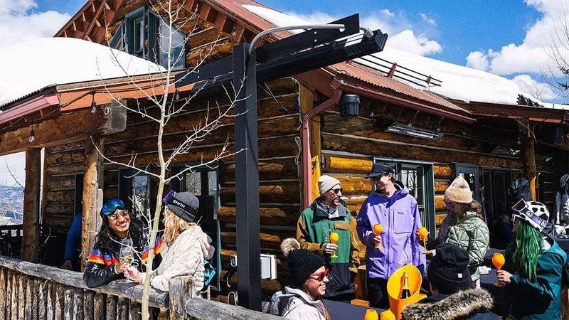Image description: Skiers enjoying drinks outside Aspen Snowmass