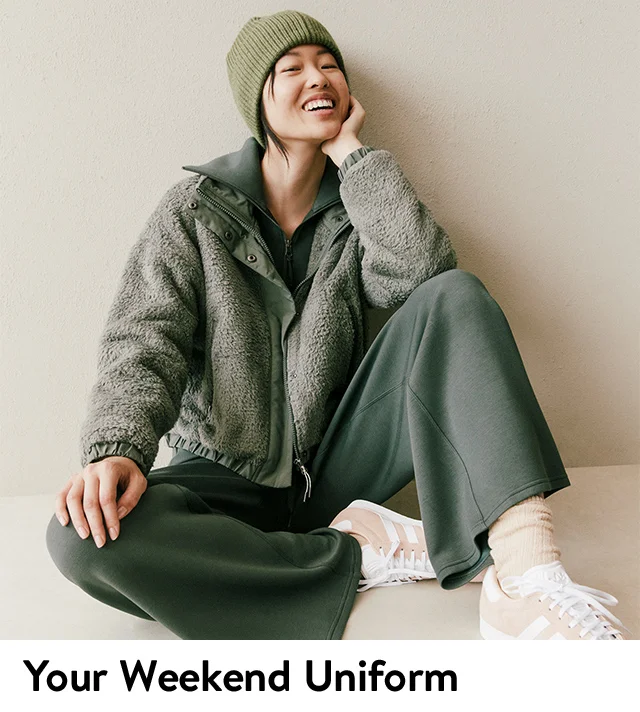 A woman wearing an active jacket, sweatshirt and sweatpants.