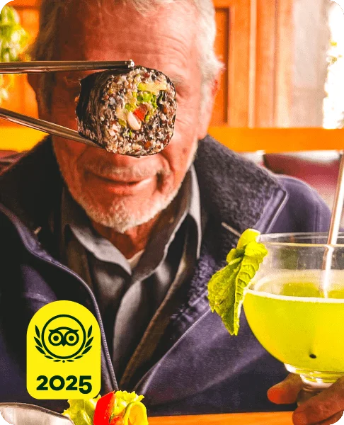 Image Description: A person with a yellow drink holding a vegetable roll with chopsticks. A yellow 2025 Travelers’ Choice Awards Best of the Best badge is on the bottom left corner of the image.