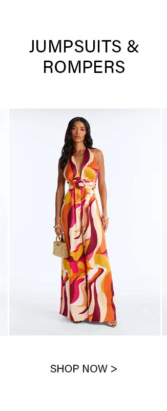 Woman in a stylish, vibrant abstract-print halter jumpsuit, holding a bag. Shop our trendy women's jumpsuits & rompers collection.