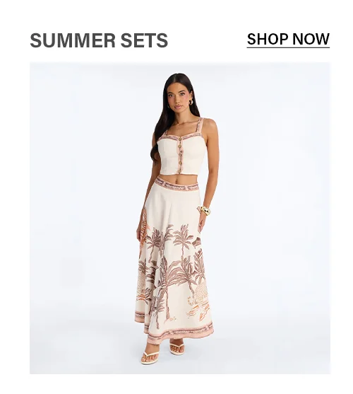 Elegant woman in a cream palm print two-piece summer set: crop top & maxi skirt. Shop women's tropical resort wear.