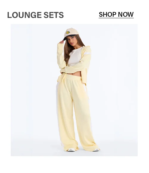 Stylish yellow women's lounge set: cropped hoodie, wide-leg sweatpants with white stripes, white crop top. Perfect for comfy casual wear.