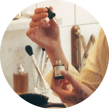 Person using the Skincare Serum in a bathroom.