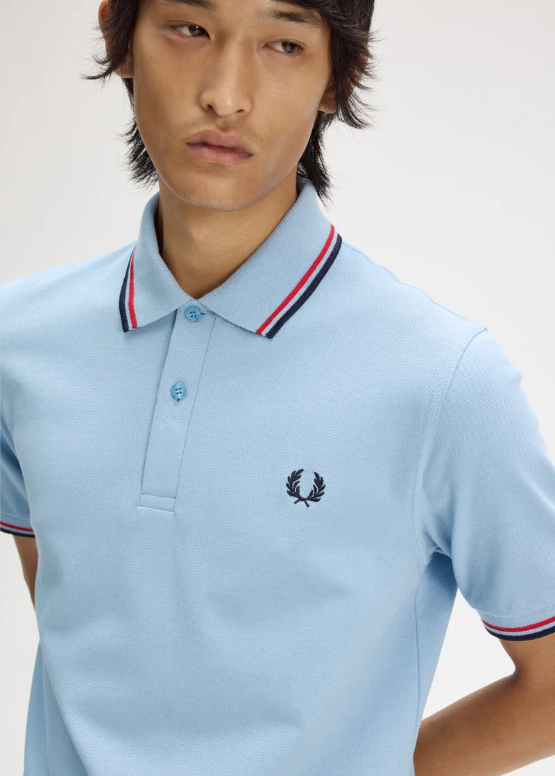 Male model wearing a M12 Fred Perry Shirt in Sky / Red / Navy