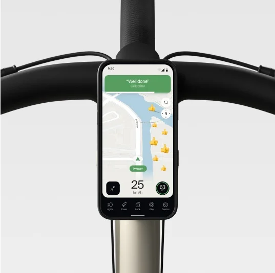 A render. Smartphone mounted on Cowboy e-bike handlebars displaying navigation and speed.