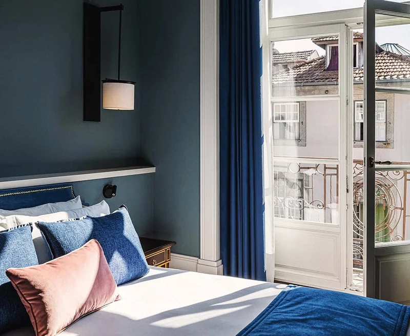 Image description: A blue hotel room with views of a charming city.