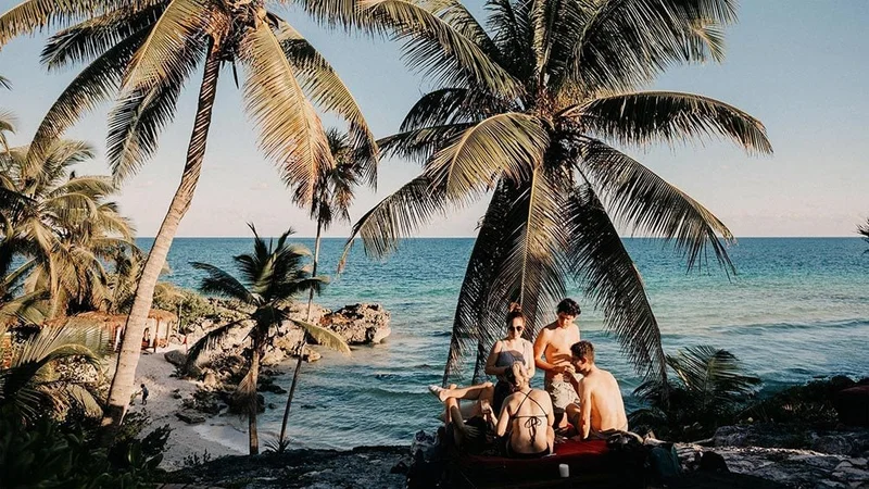 Image description: A group of friends hanging out on the beach in Tulum, Mexico
