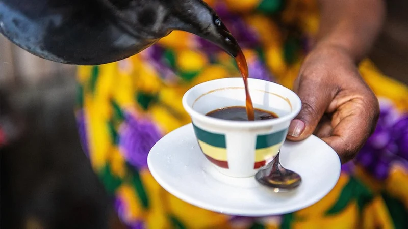 Image description: A woman pours a cup of coffee in Addis Ababa, Ethiopia