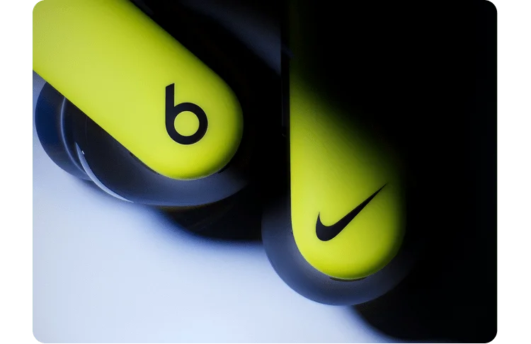 Close-up of the Nike Powerbeats Pro 2 earbuds with Beats and Nike logos.