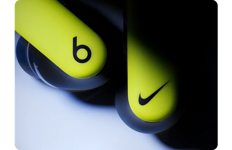 Close-up of the Nike Powerbeats Pro 2 earbuds with Beats and Nike logos.