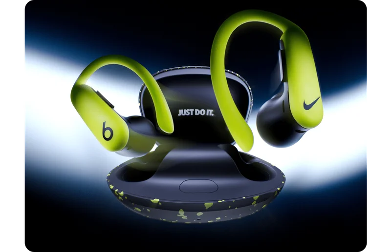 A pair of special-edition Nike Powerbeats Pro 2 earbuds and charging case floating against a dark background.