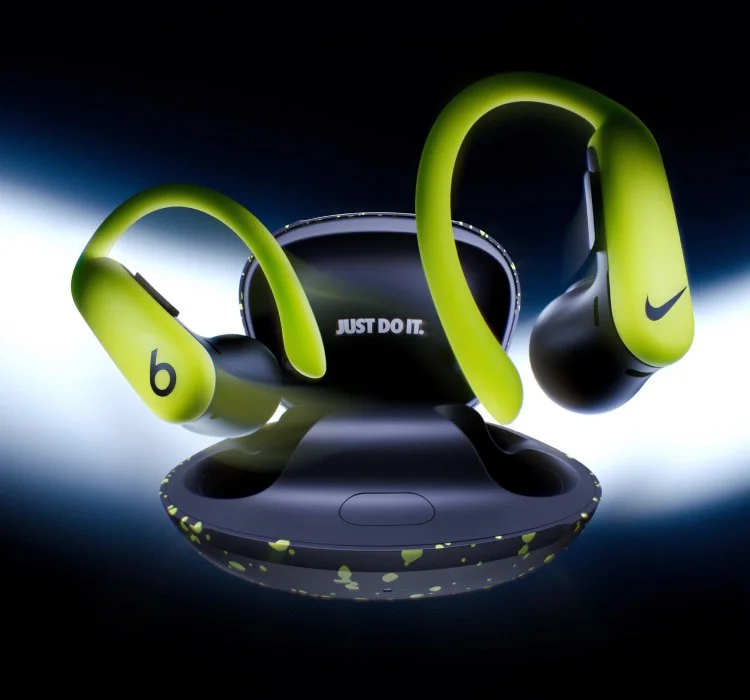 A pair of special-edition Nike Powerbeats Pro 2 earbuds and charging case floating against a dark background.