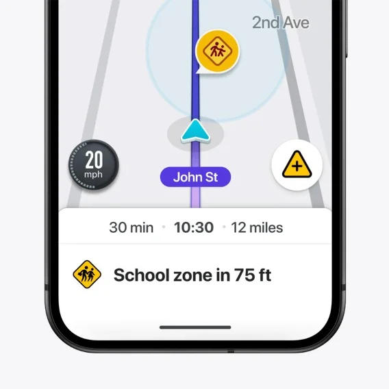 A detailed close-up of a smartphone screen with Waze open. The app shows a map with a blue route line with a yellow school zone warning sign with children on it, indicating a school zone in 75 feet.