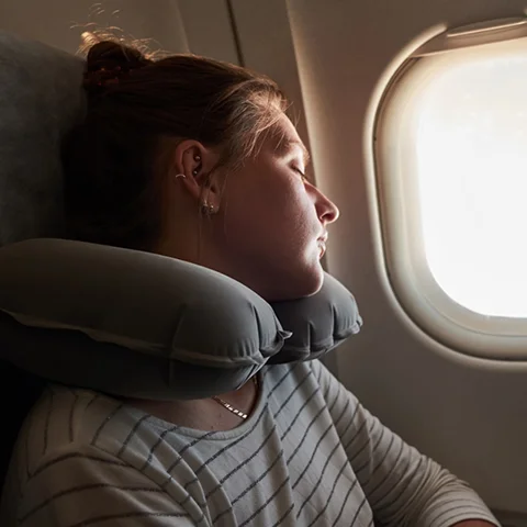 A girl is illuminated by light near a window.