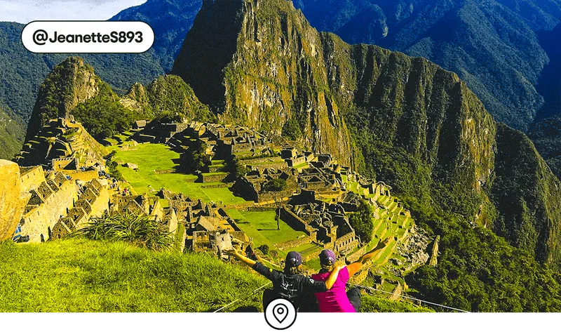 Image description: Two travelers looking down over Machu Picchu, photo taken by @JeanetteS893