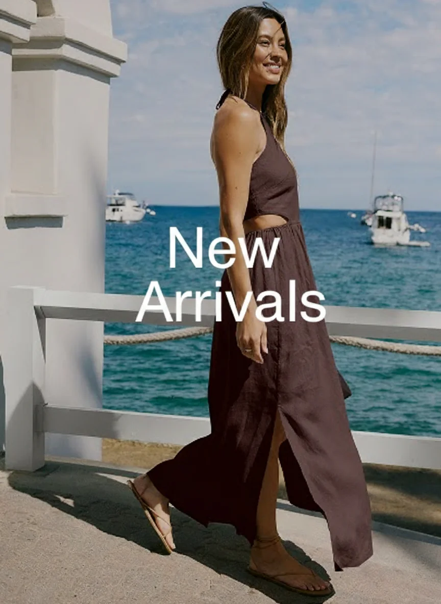 Woman in a brown dress walks by the ocean with "New Arrivals" text overlay.