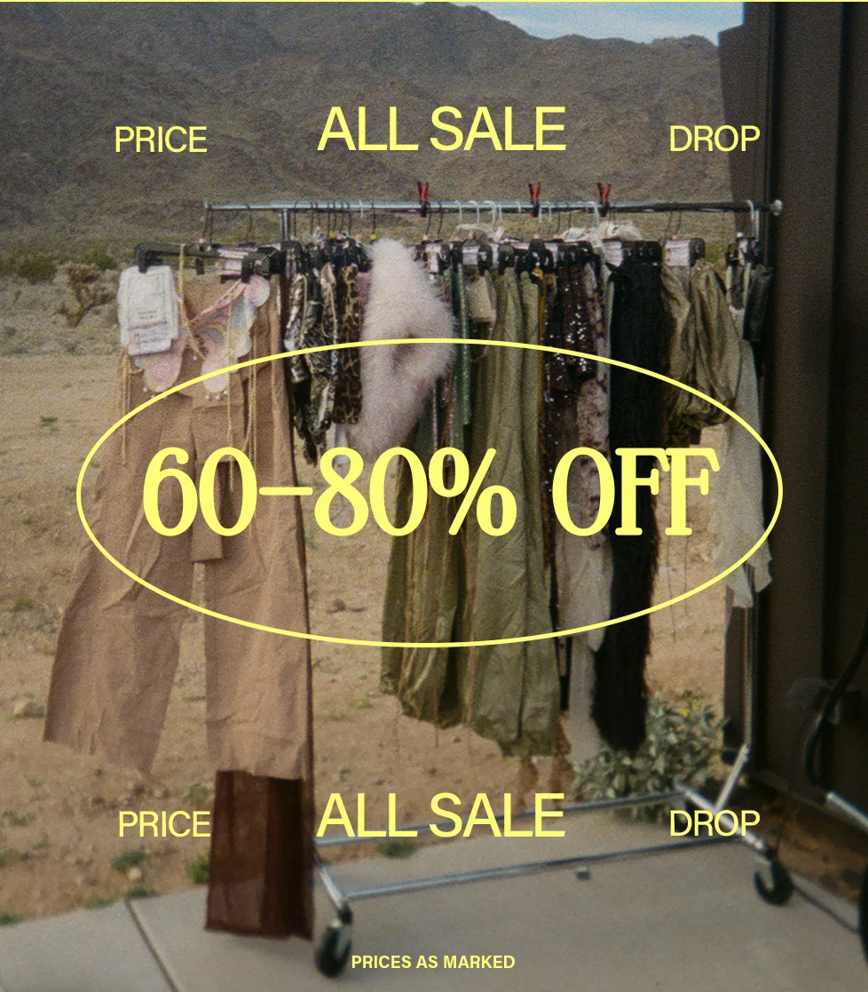 Assorted fashion apparel on a rack in a desert landscape, including earthy trousers and sparkly tops. Huge 60-80% off price drop sale on clothing!