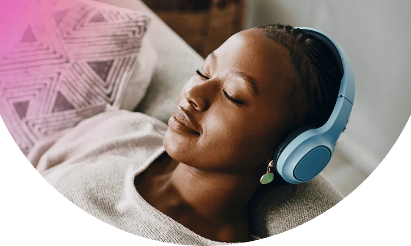 Woman with eyes closed listening to Calm through wireless headphone