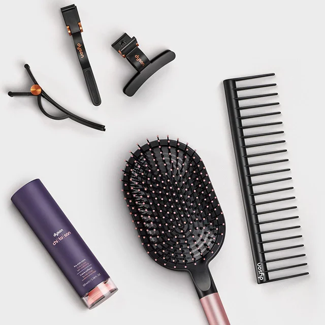 Dyson Chitosan Pre-style cream surrounded by a range of Dyson Beauty attachments and accessories