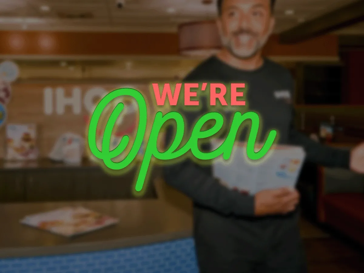 We're Open text is centered on a soft-focus image of a server at IHOP