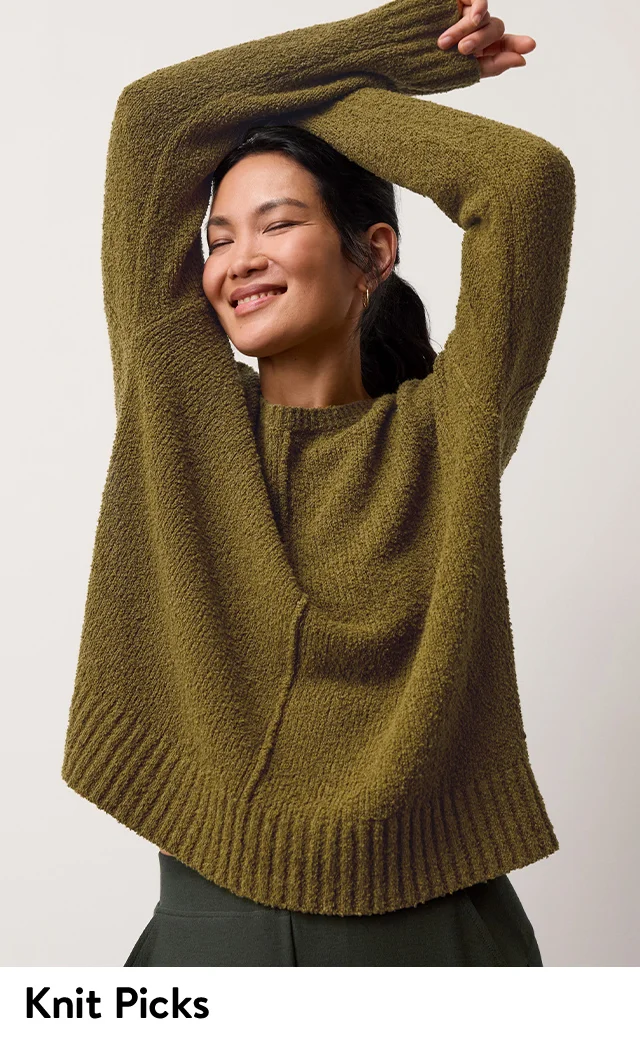 A woman wearing a green crewneck sweater.