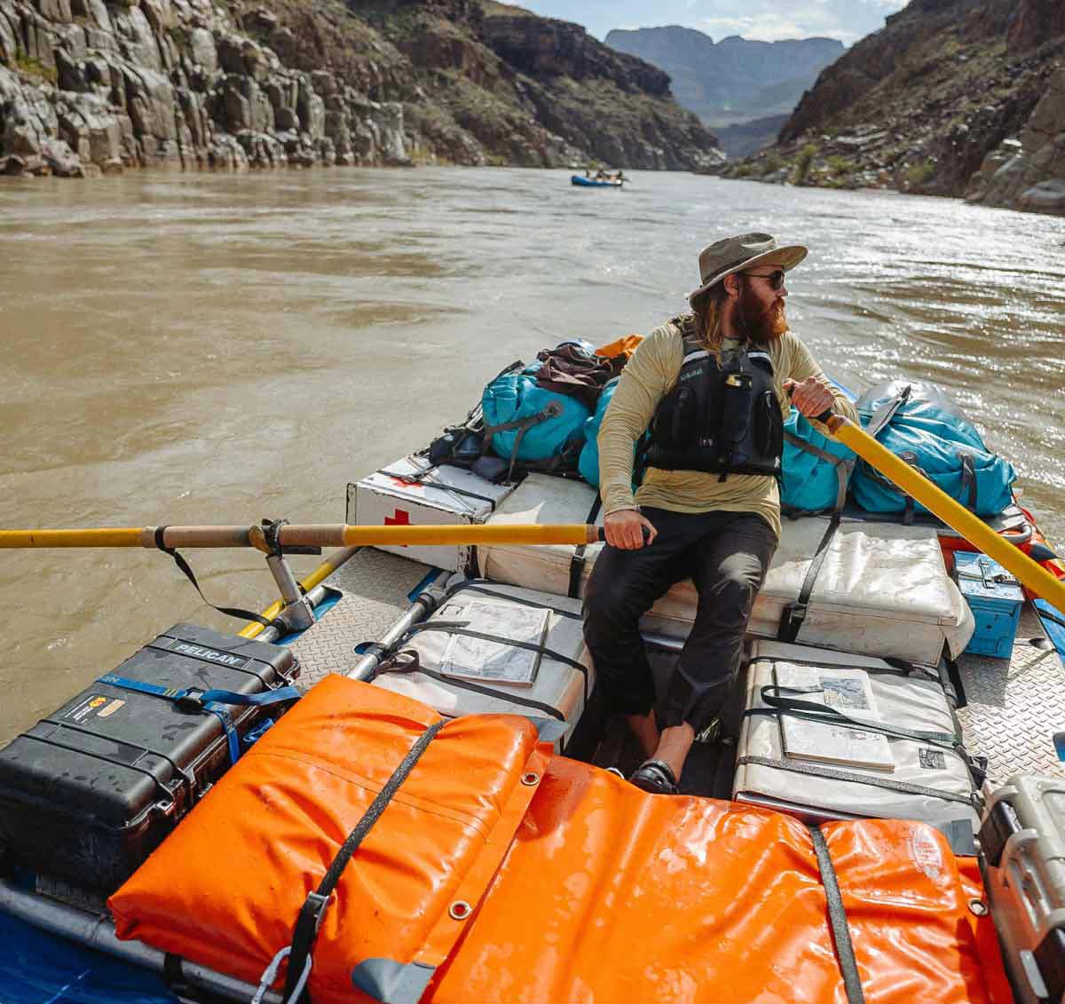 A rafter rows a gear boat down the Grand Canyon.