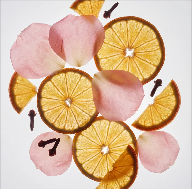 Dried orange slices, rose petals, and cloves flat lay