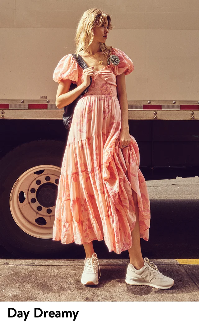 A woman wearing a pink puff-sleeve dress with a floral pattern.