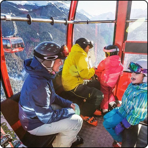 Image Description: A family in ski gear rides up a covered ski lift.