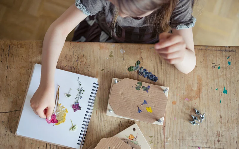 child pressing flowers