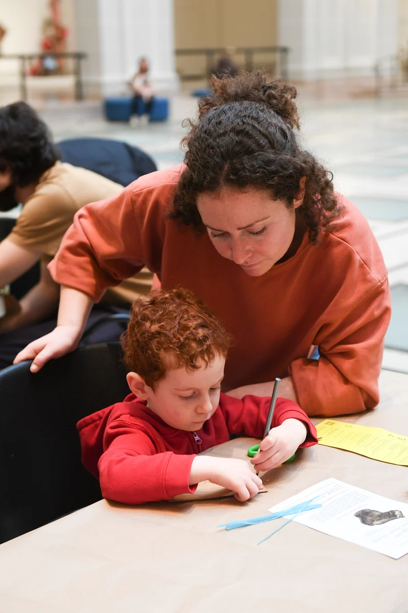 An adult and child drawing at a table