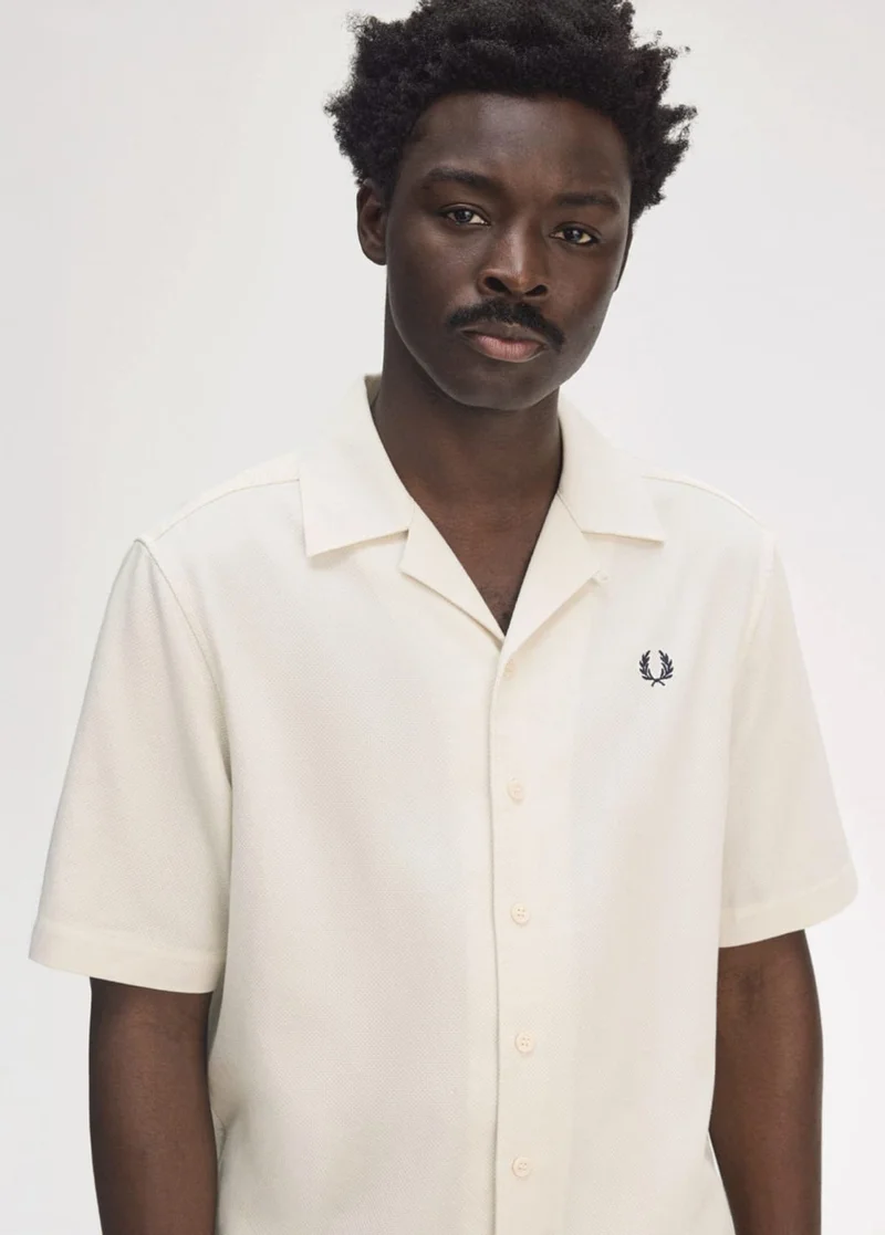 Black man wears crisp revere-collared shirt in ecru