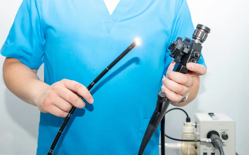 A health professional prepares a camera for a colonoscopy.