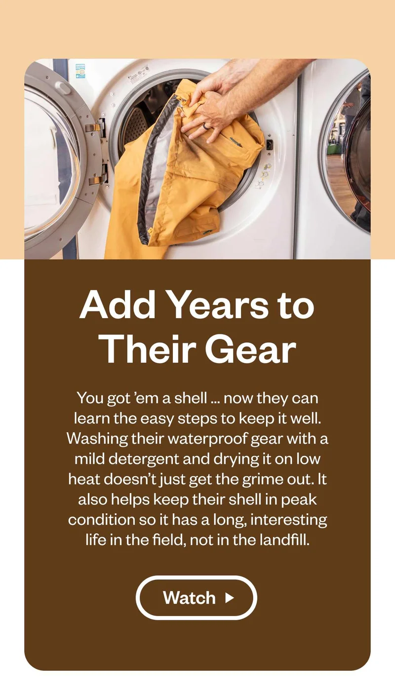 A person puts a waterproof jacket in a washing machine. Add Years to Their Gear You got ’em a shell ... now they can learn the easy steps to keep it well. Washing their waterproof gear with a mild detergent and drying it on low heat doesn’t just get the grime out. It also helps keep their shell in peak condition so it has a long, interesting life in the field, not in the landfill. Watch