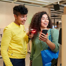 An IKEA co-worker and a customer scanning items