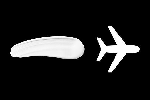 A streak of Dyson Chitosan Pre-style cream next to an icon of an airplane.