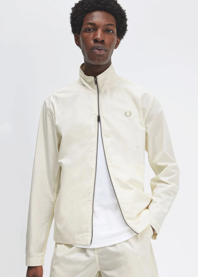 Man wearing a zip up ecru lightweight jacket