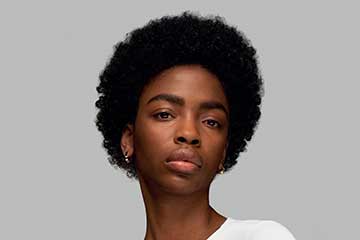 Model with dark, coily hair styled into a soft twist.