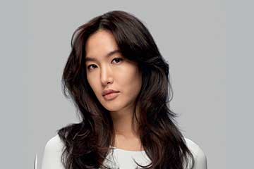 Model with long, dark hair styled into an S-shaped blowout.