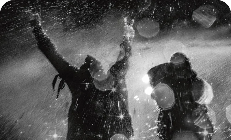 Two people getting sprayed by a hose.