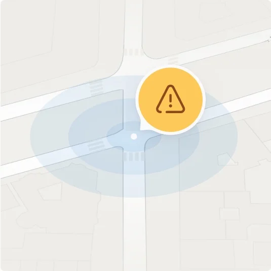 Map interface highlighting a yellow caution symbol near a roundabout, indicating a potential hazard ahead.