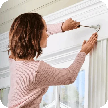 Person setting up a security mount on the exterior of a house.